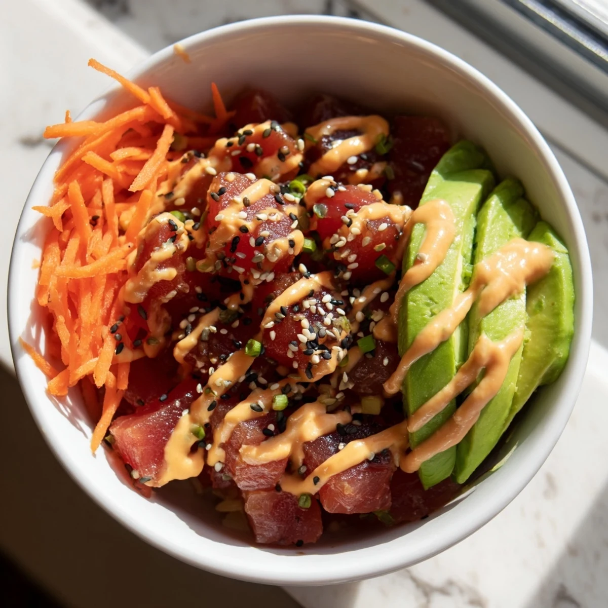 A vibrant Spicy Tuna Poke Bowl with Sriracha Mayo featuring fresh tuna, creamy avocado, and crunchy cucumber over rice.