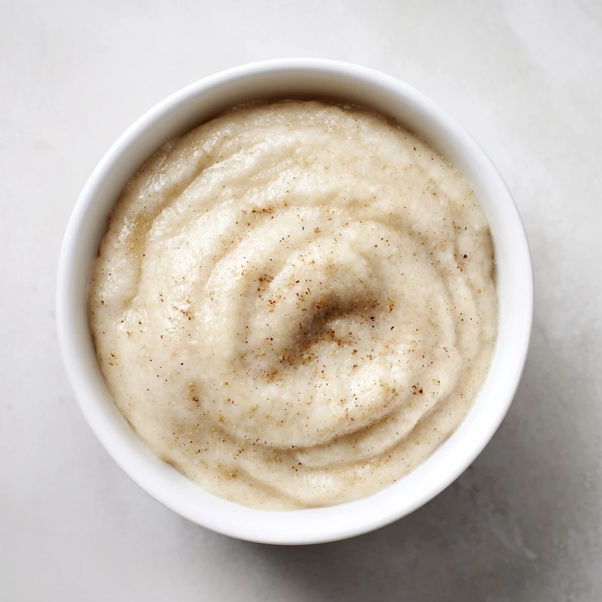 Winter Smoothie Blend in a tall glass, creamy texture topped with cinnamon and a tart cranberry garnish.