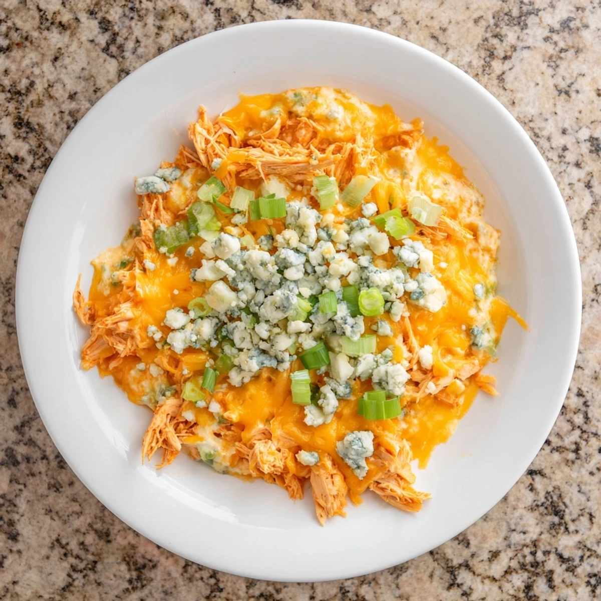 Creamy, spicy Touchdown Buffalo Chicken Dip with shredded chicken, gooey cheddar, and tangy hot sauce, served with celery sticks.  