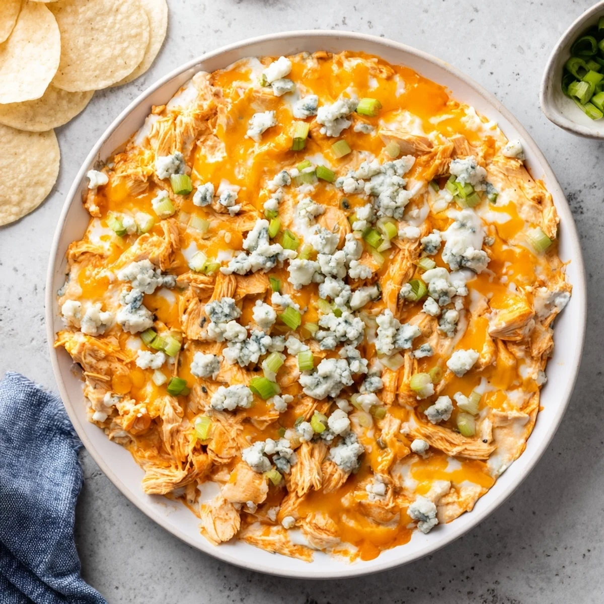 Hot and bubbly Touchdown Buffalo Chicken Dip fresh from the oven, garnished with green onions and paired with crunchy tortilla chips.  
