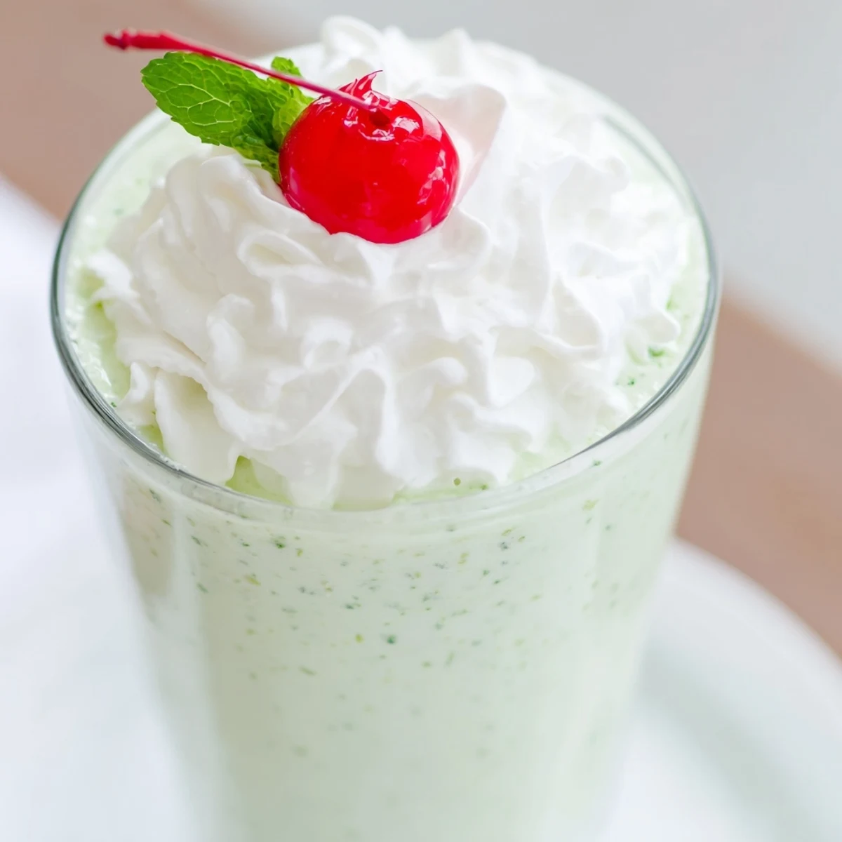 This creamy Mint Milkshake with Maraschino Cherry blends vanilla ice cream and peppermint, crowned with whipped cream and a sweet cherry.