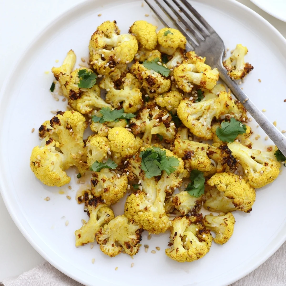 Turmeric roasted cauliflower florets, perfectly golden and crisp, ready to serve as a healthy vegan side dish.