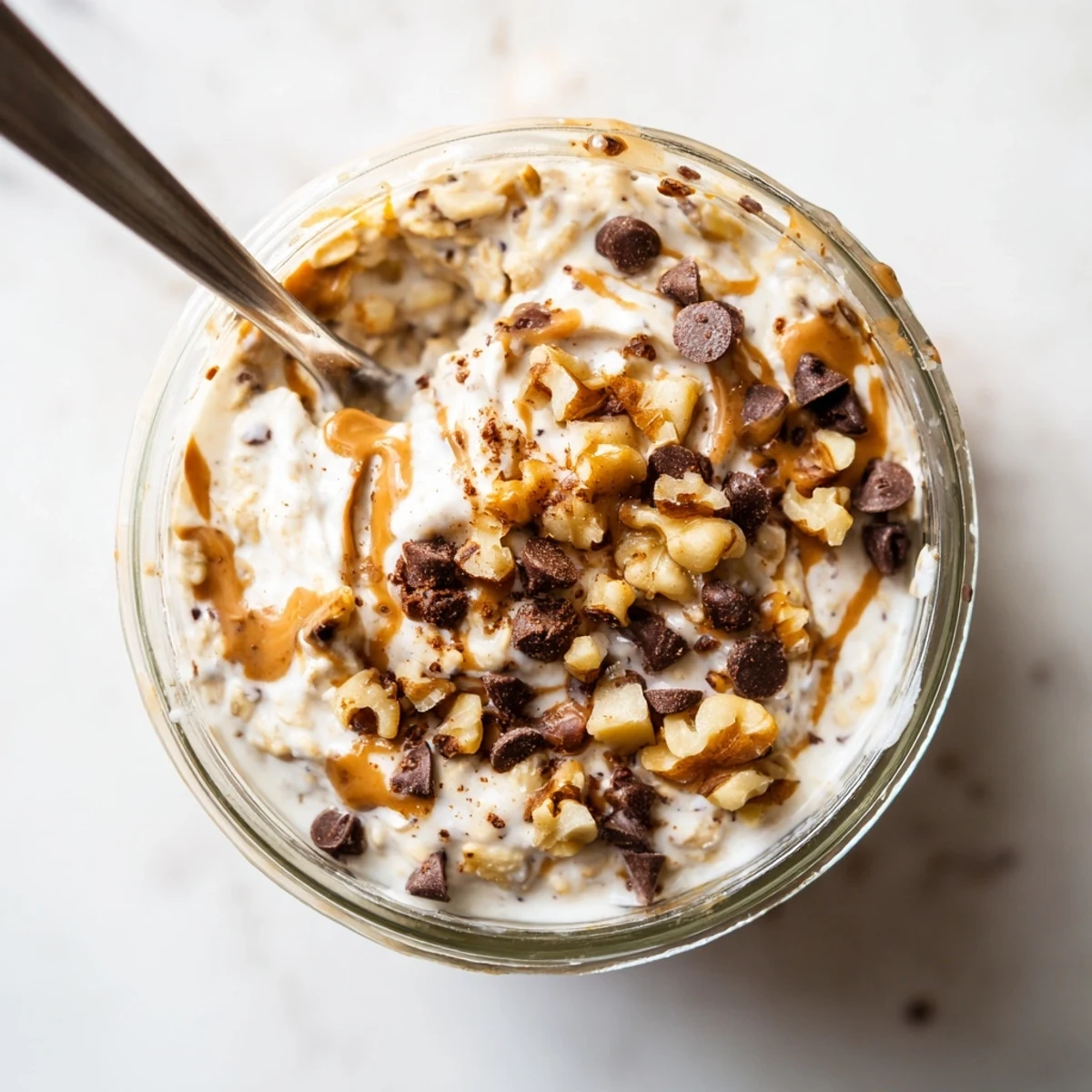 Easy American breakfast of Cookie Dough Overnight Oats with Greek yogurt and maple syrup in a clear bowl.