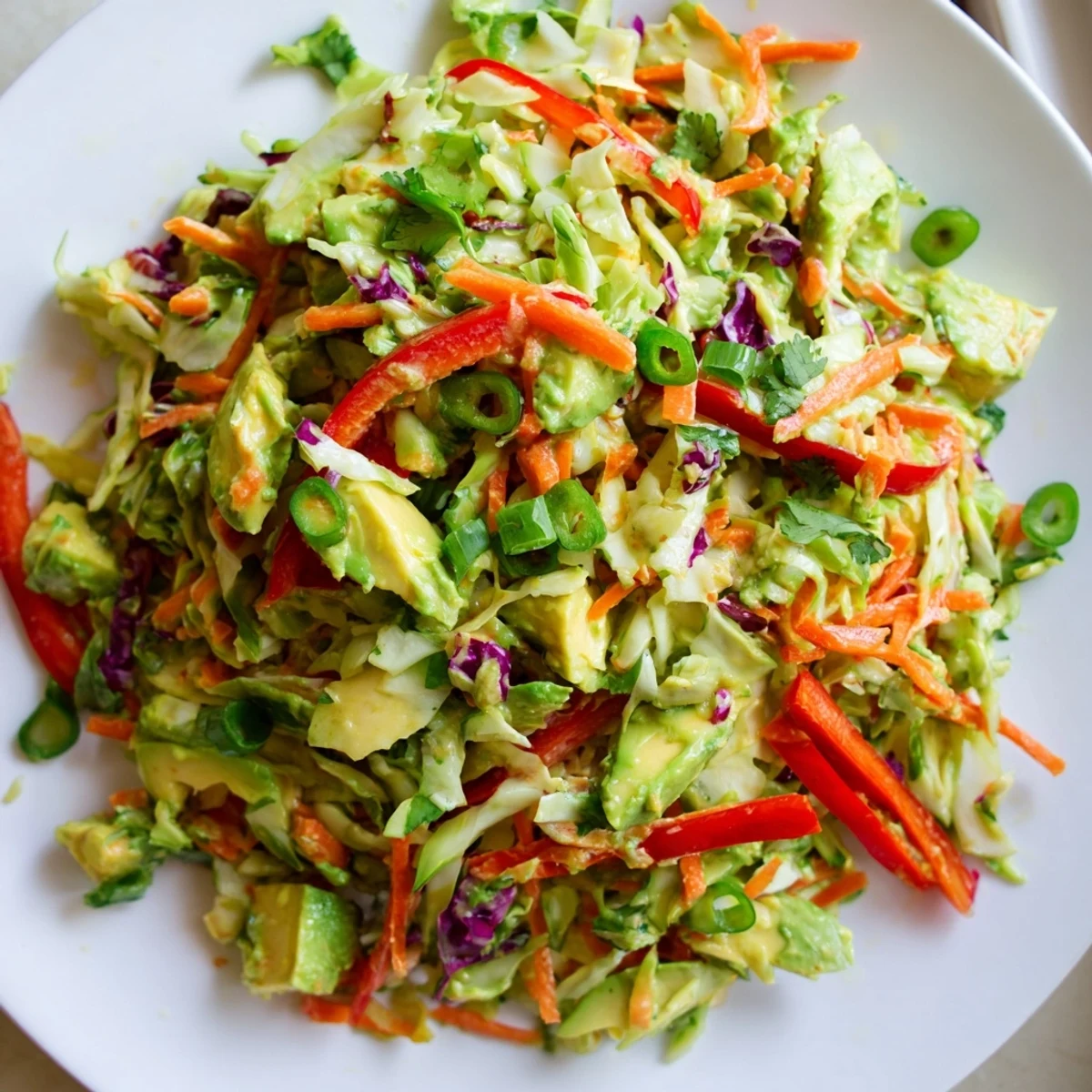Vibrant avocado cabbage salad with creamy avocado, crunchy cabbage, and lime dressing in a rustic bowl.  