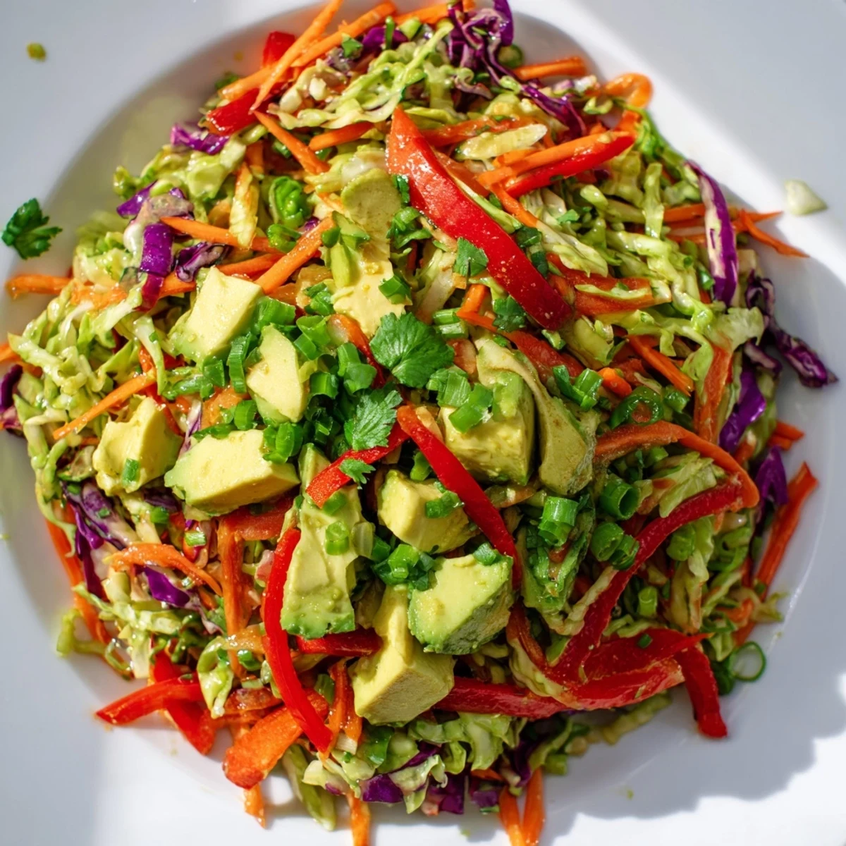 Freshly tossed avocado cabbage salad topped with toasted pumpkin seeds and cilantro for a light lunch.  