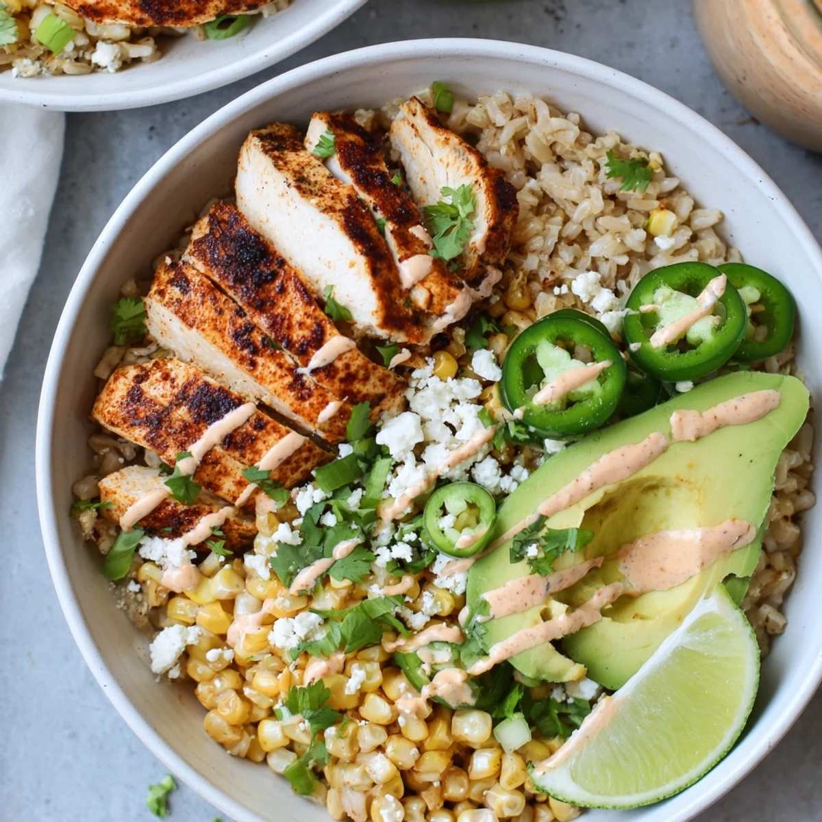 The Street Corn Chicken Bowl features juicy grilled chicken, golden charred corn, avocado, and cilantro on a bed of fluffy rice.