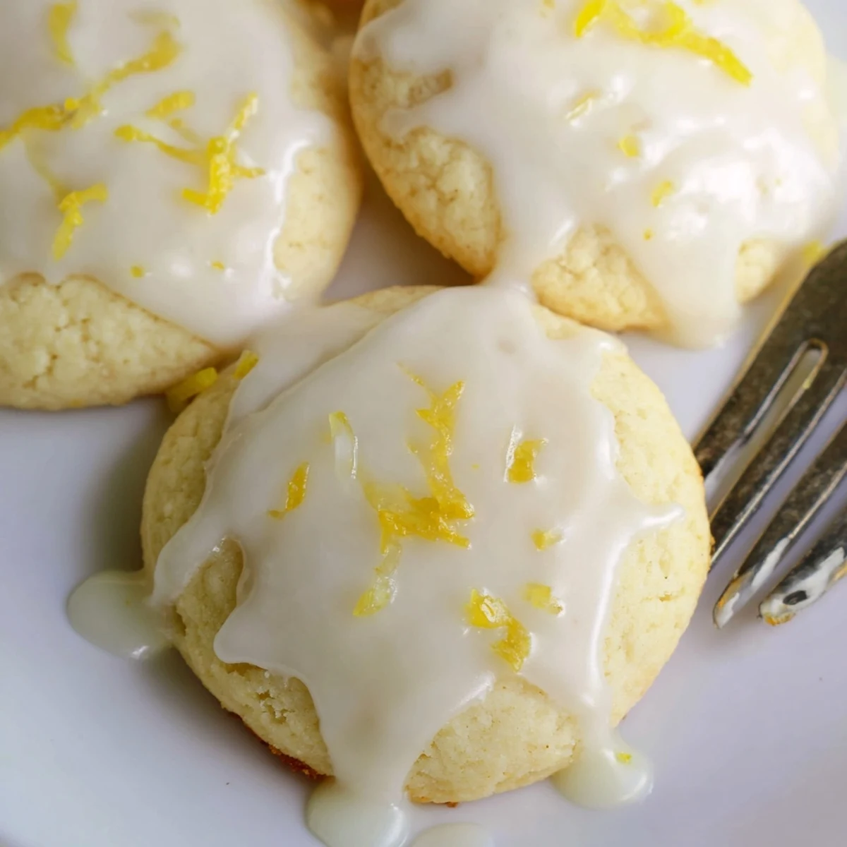 Freshly baked Limoncello cookies arranged on a cooling rack with a sweet lemon glaze dripping slightly, perfect for spring gatherings.