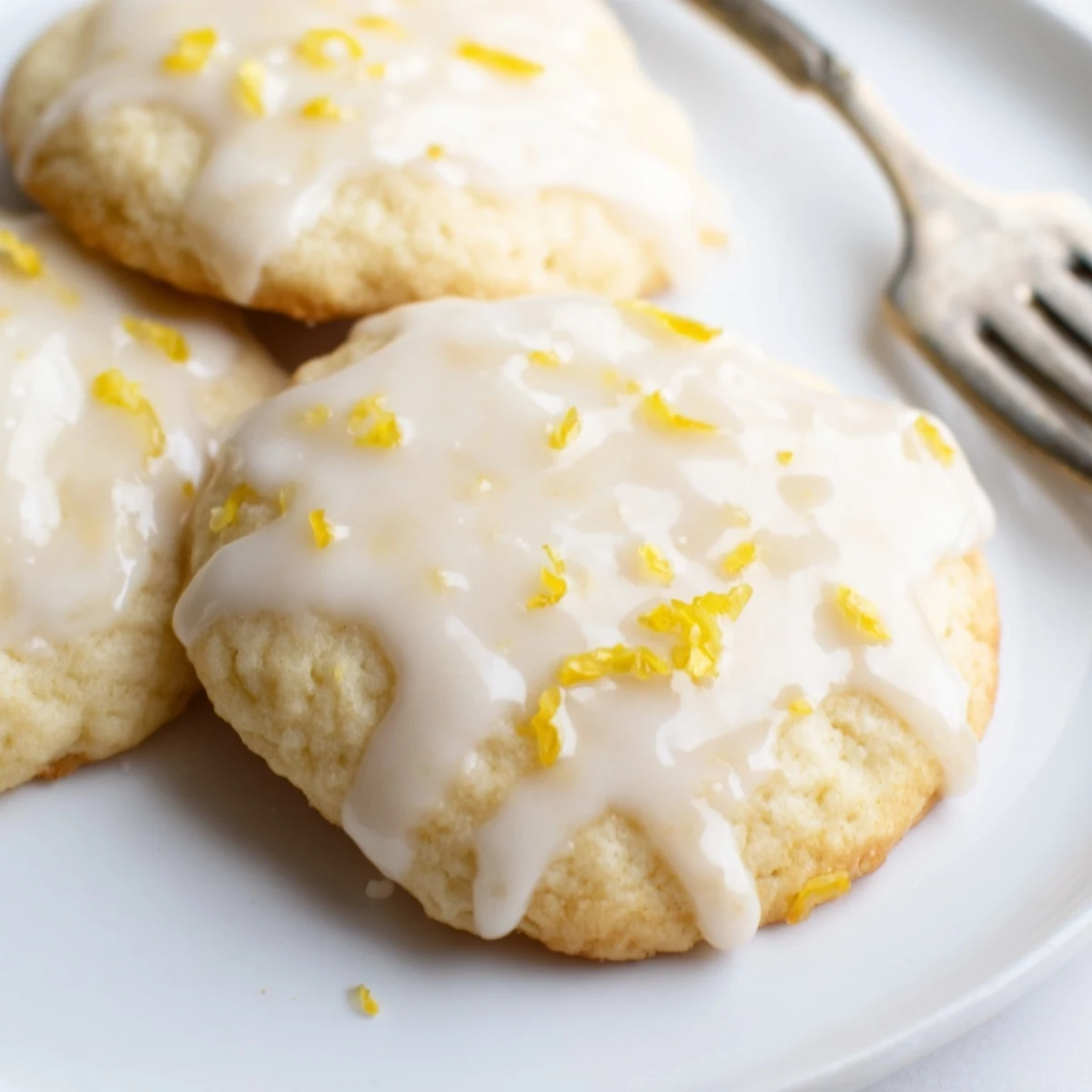 Overhead view of golden Limoncello cookies drizzled with glaze and lemon zest, ready to serve with afternoon tea.