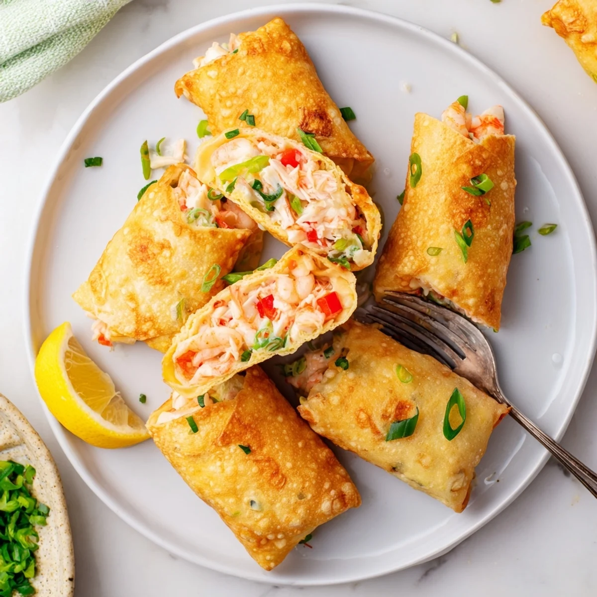 Golden fried Cheesy Seafood Tortilla Bombs shine on a plate beside lemon wedges and a creamy dip.