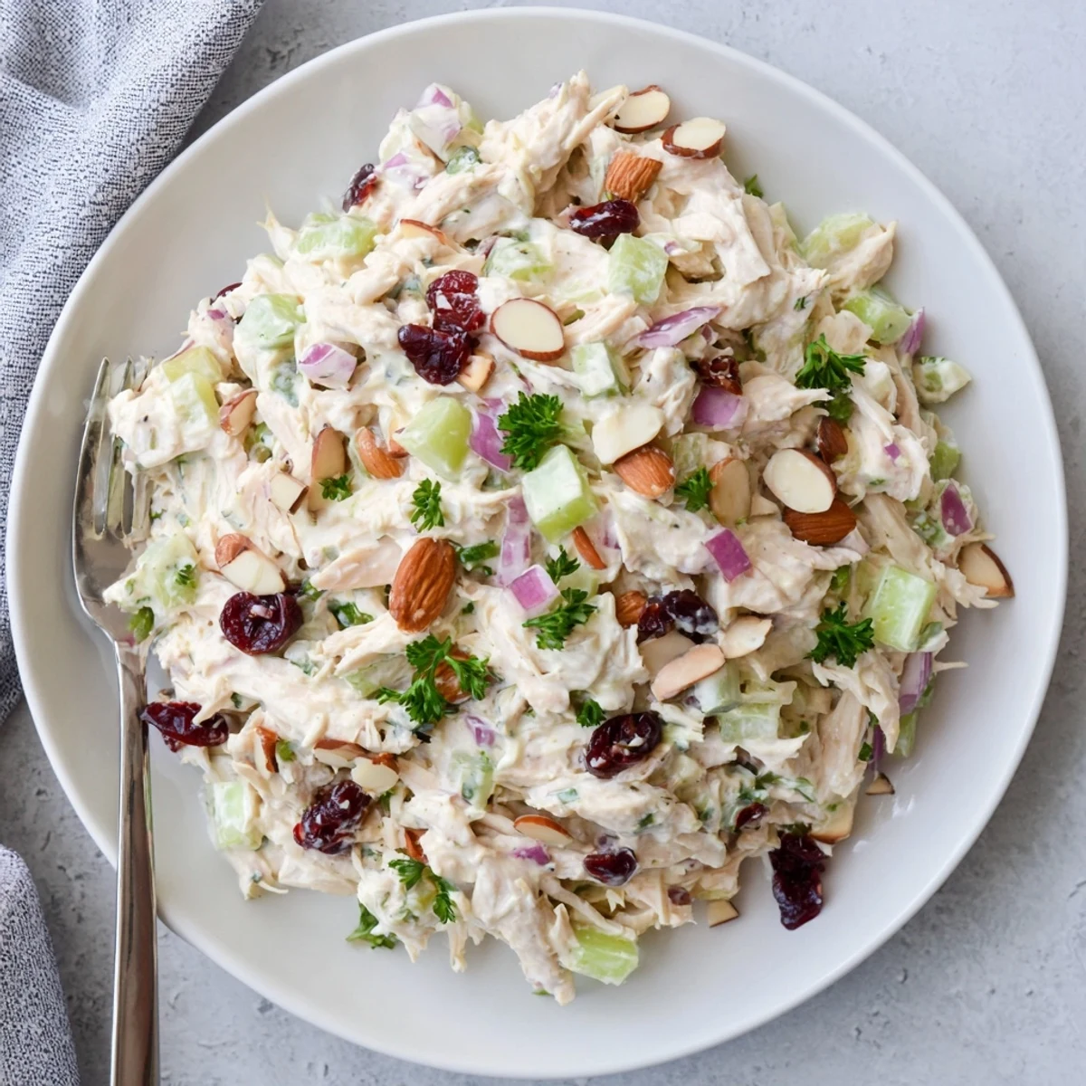 Creamy Greek yogurt rotisserie chicken salad with crisp colorful vegetables and fresh herbs served in a white bowl.