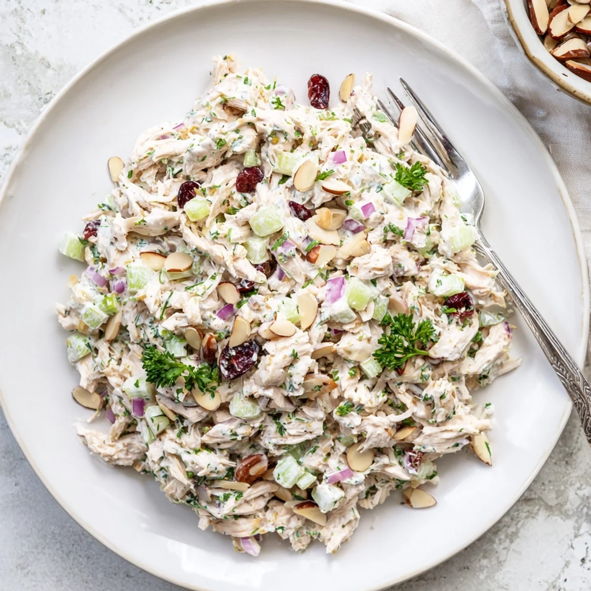 Healthy Greek yogurt rotisserie chicken salad featuring tender shredded chicken, crunchy bell peppers, and celery on a bed of lettuce.