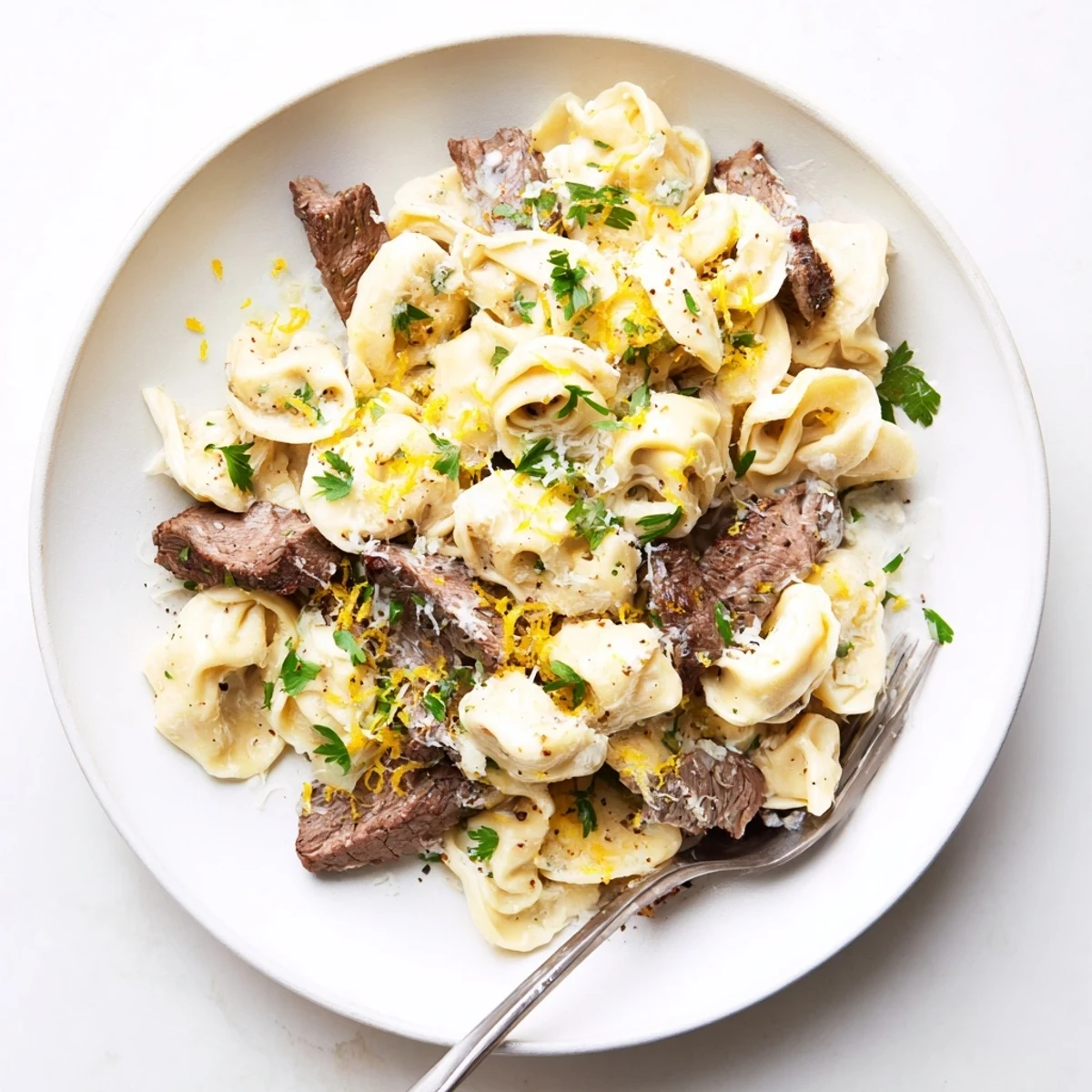 Savory sirloin tortellini pasta coated in parmesan creamhouse sauce with cracked garlic and red pepper flakes