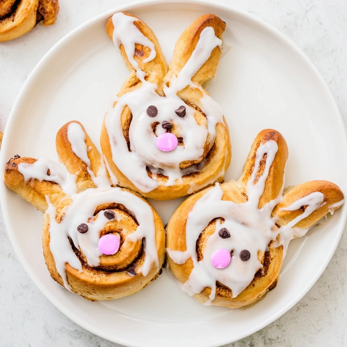 Freshly baked Easter Bunny cinnamon rolls arranged on serving platter featuring ear-shaped pastry and cinnamon swirls