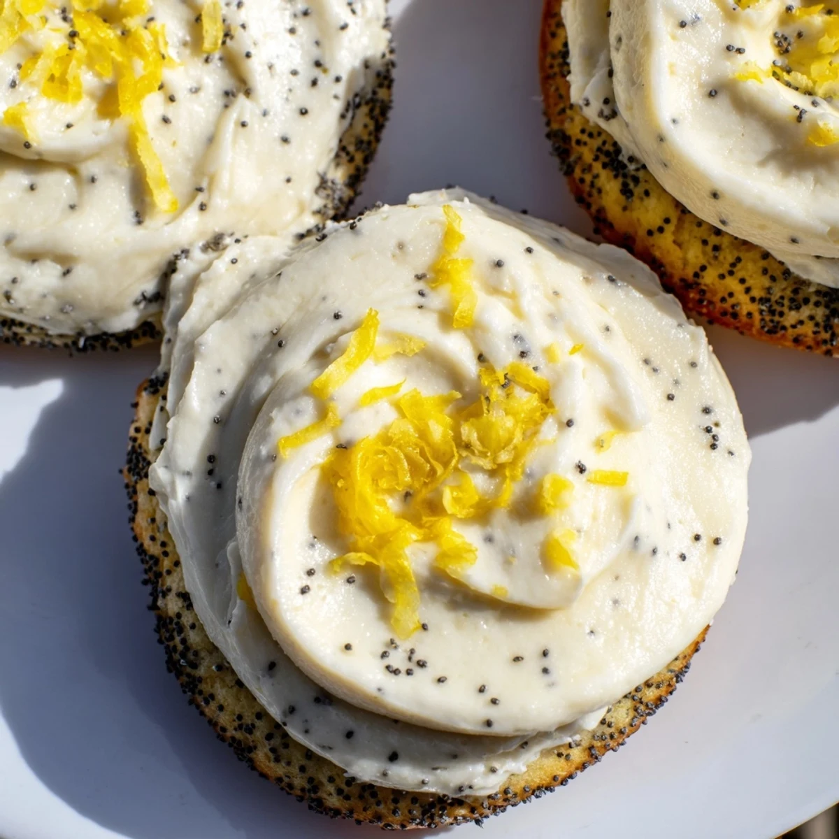 Close-up of frosted lemon poppy seed cookies with tangy cheesecake topping and zest