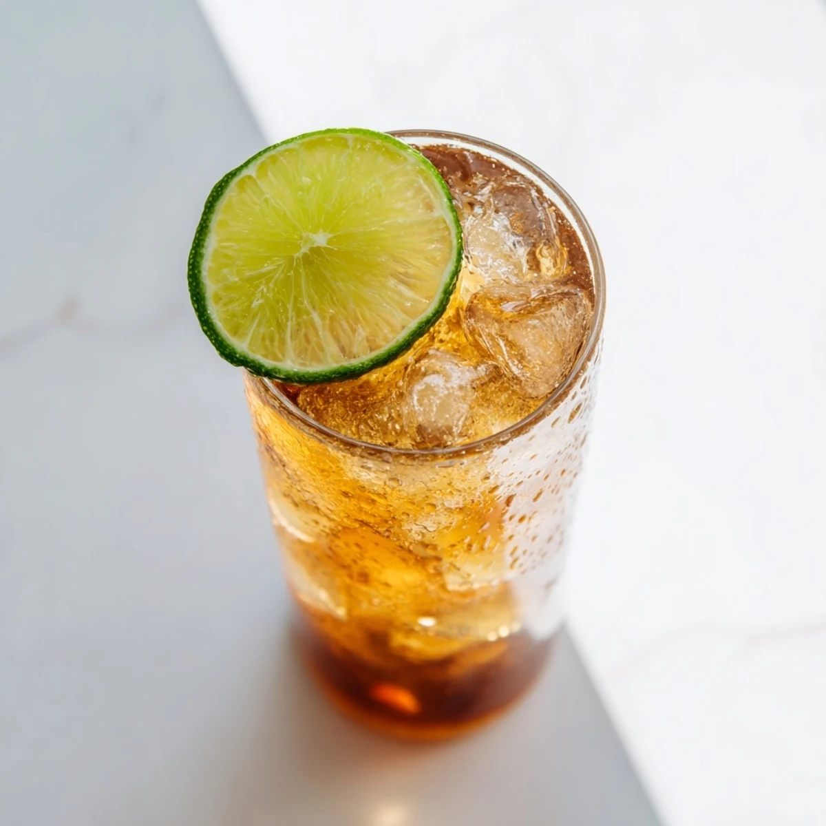 Golden Thai lime iced tea served in tall glasses over ice with fresh lime garnish