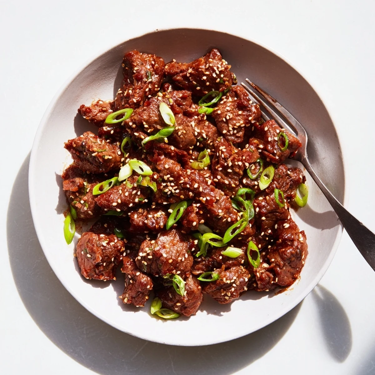 Melt-in-your-mouth slow cooker Korean beef featuring rich caramelized sauce pieces served in fresh crisp lettuce cups with toasted sesame seed garnish.