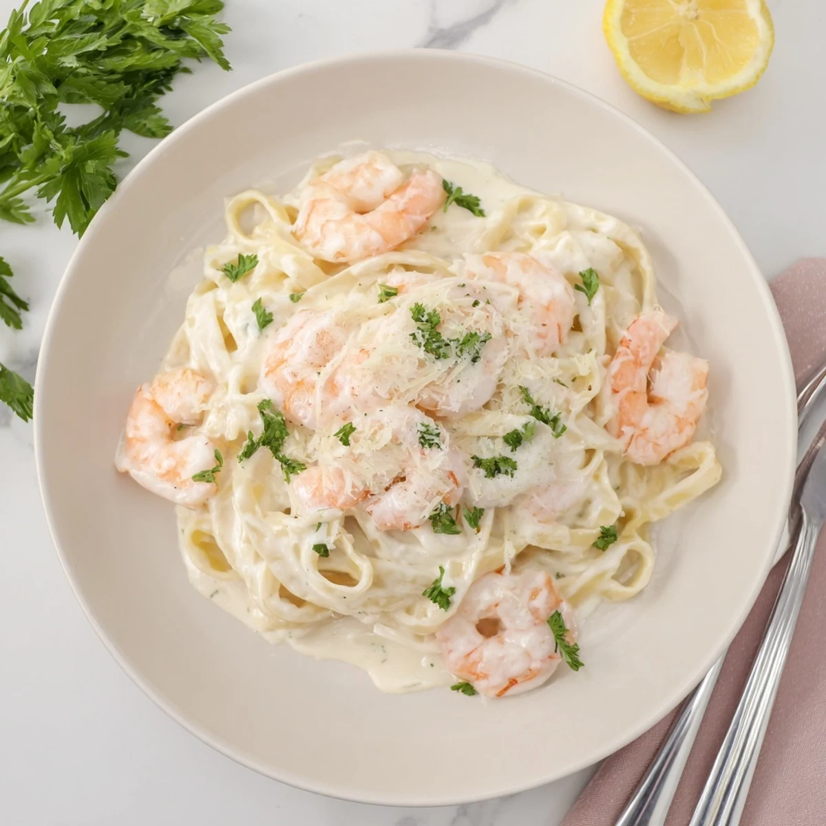 Golden shrimp draped over fettuccine noodles coated in rich Parmesan Alfredo sauce