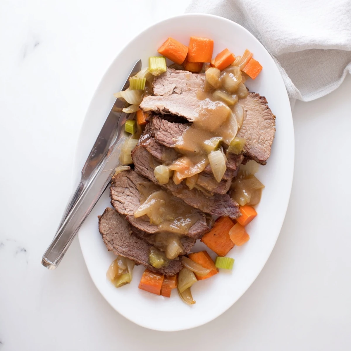 Fork-tender slow cooker beef brisket resting on a platter with roasted vegetables and savory gravy