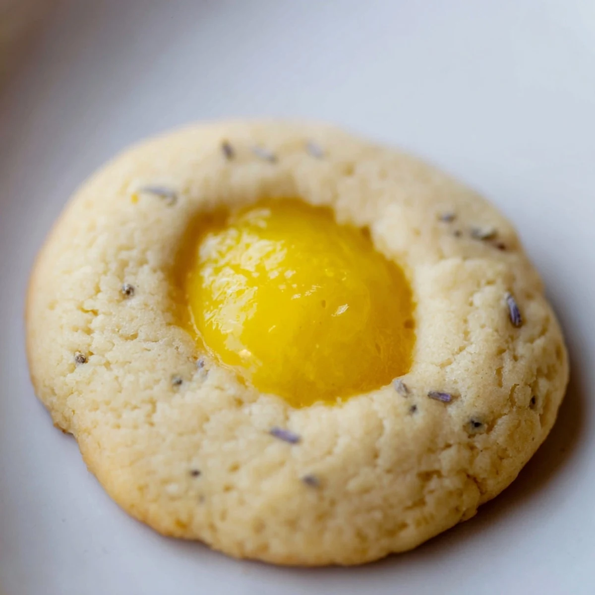 Freshly baked lemon lavender thumbprint cookies with sweet jam filling arranged for afternoon tea serving