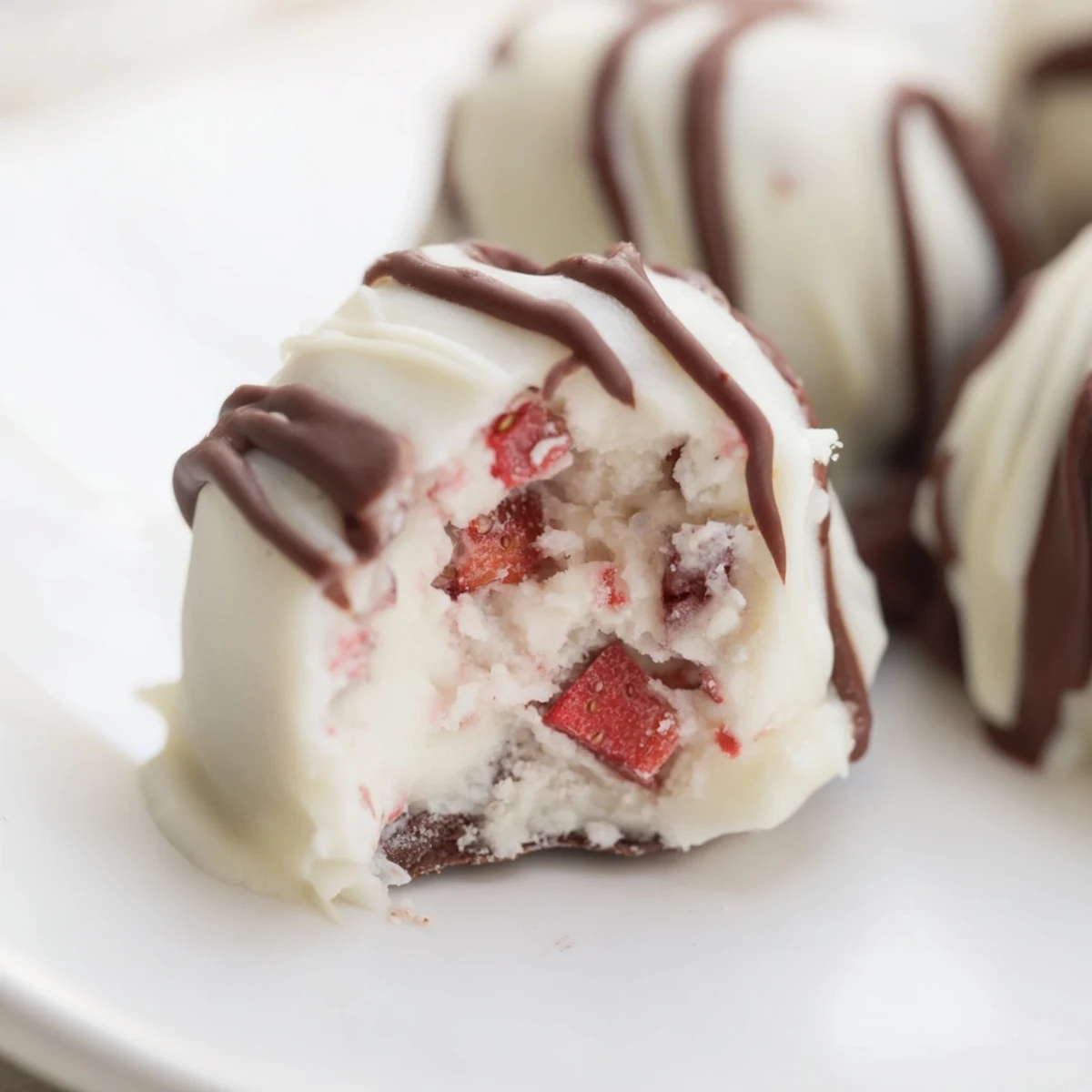 Frozen strawberry high protein yogurt bites arranged on a baking sheet, showcasing smooth yogurt texture mixed with diced fresh berries