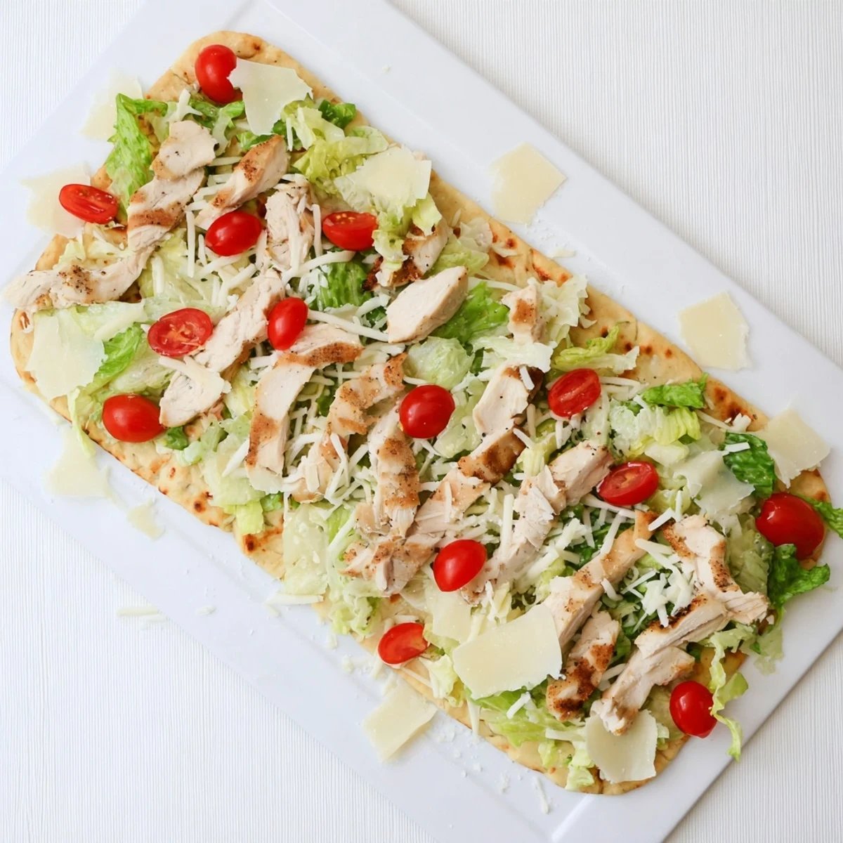 Golden Chicken Caesar Flatbread with grilled chicken, melted cheese, and crisp romaine lettuce drizzled with creamy dressing