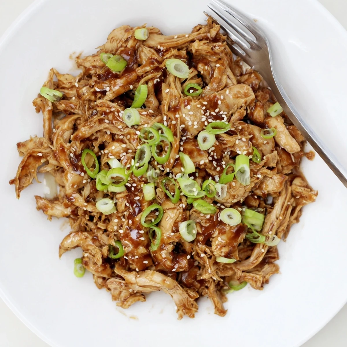 Tender shredded Crockpot Teriyaki Chicken coated in glossy sweet and savory homemade glaze