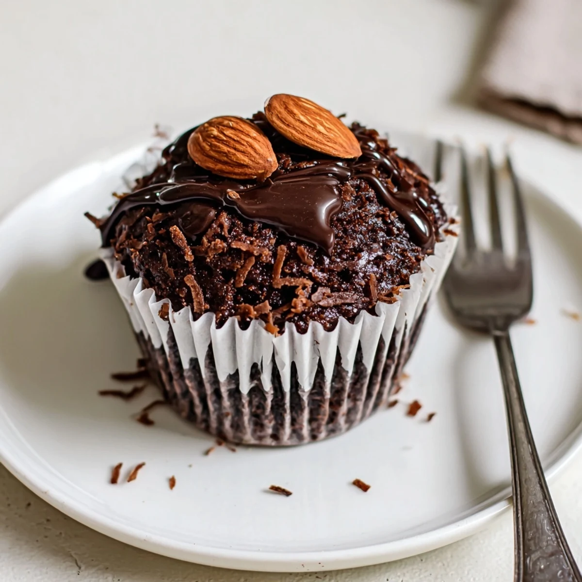 Decadent Flourless Almond Joy Cupcakes with coconut filling peeking through fudgy chocolate centers