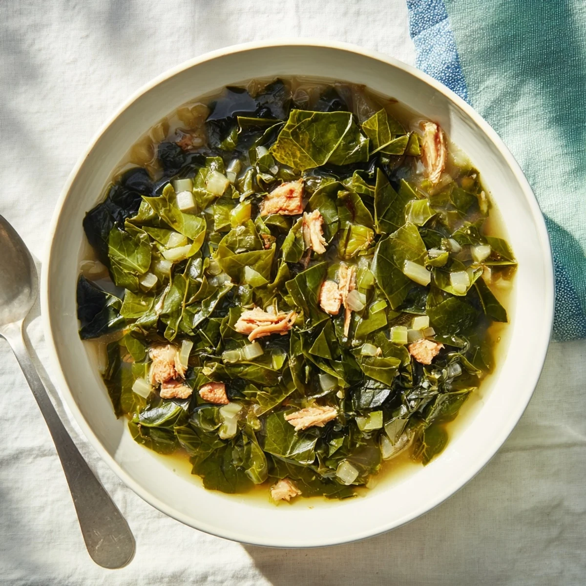 Hearty collard greens recipe featuring wilted leaves with onions and savory smoked turkey leg