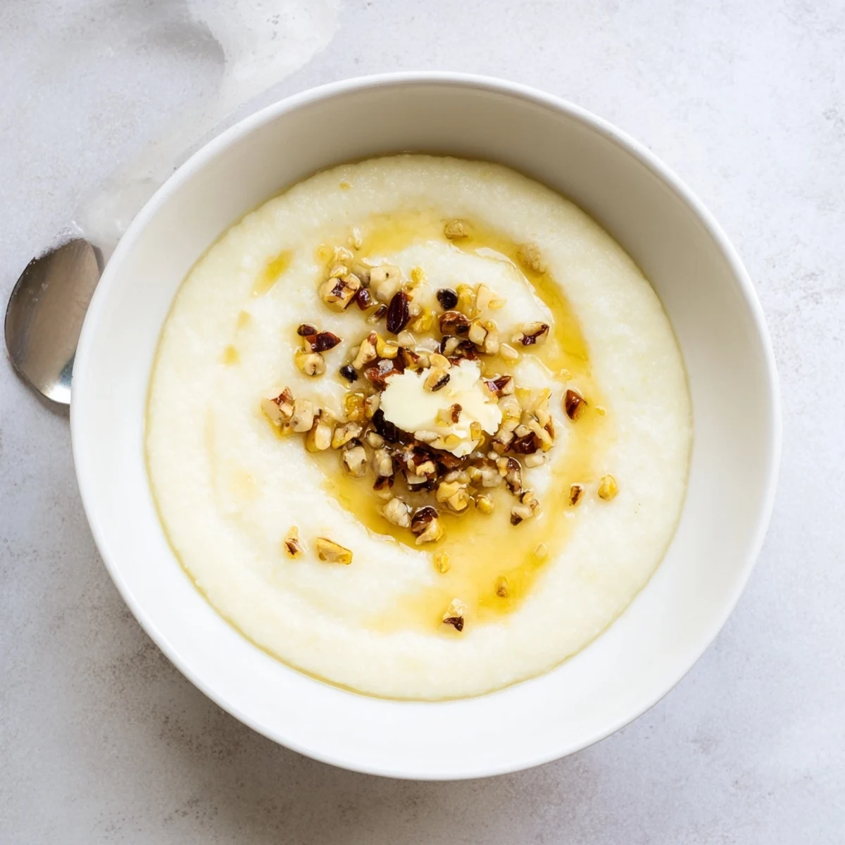 Smooth African maize porridge steaming hot in a white ceramic bowl with butter melting