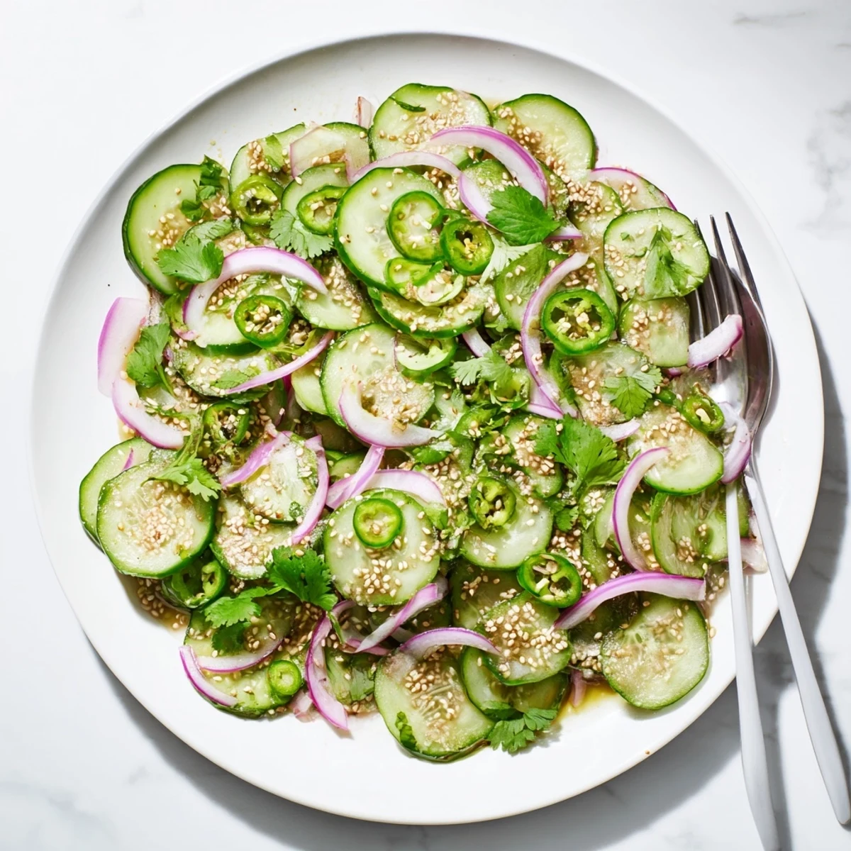Vibrant cucumber salad featuring red onion and cilantro tossed in sweet honey lime glaze