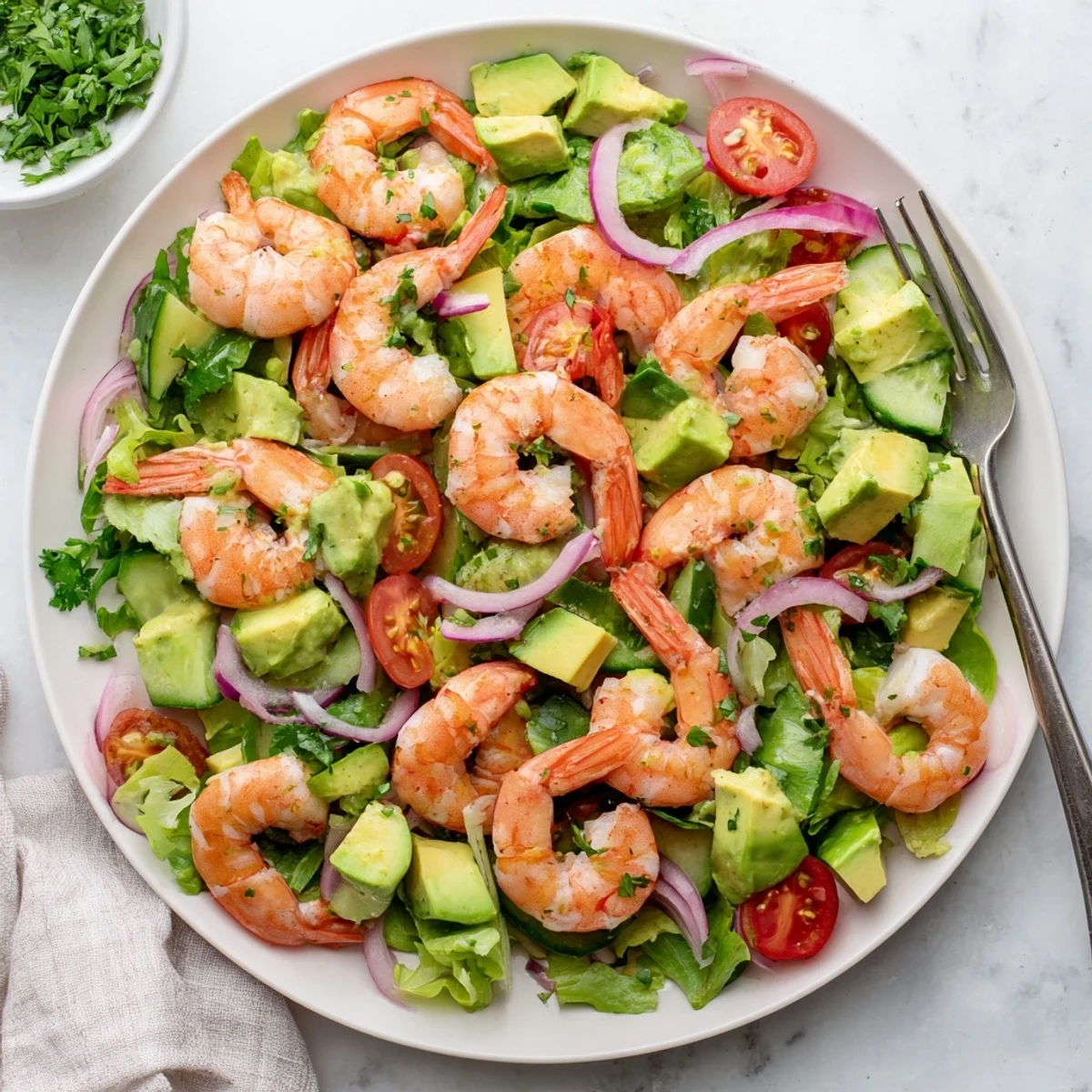 Fresh shrimp avocado salad recipe with crisp vegetables and zesty citrus dressing on white plate