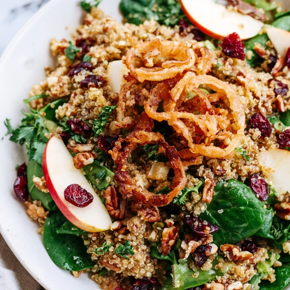 Honey Mustard Quinoa Apple Salad topped with golden crispy shallots in a bowl