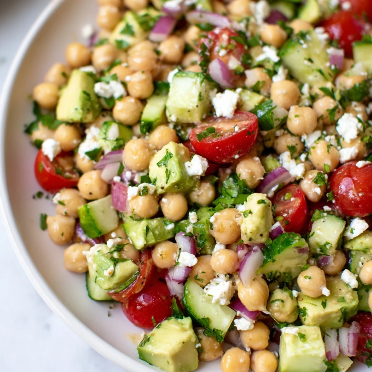 Creamy chickpea feta avocado salad tossed with cherry tomatoes and fresh herbs