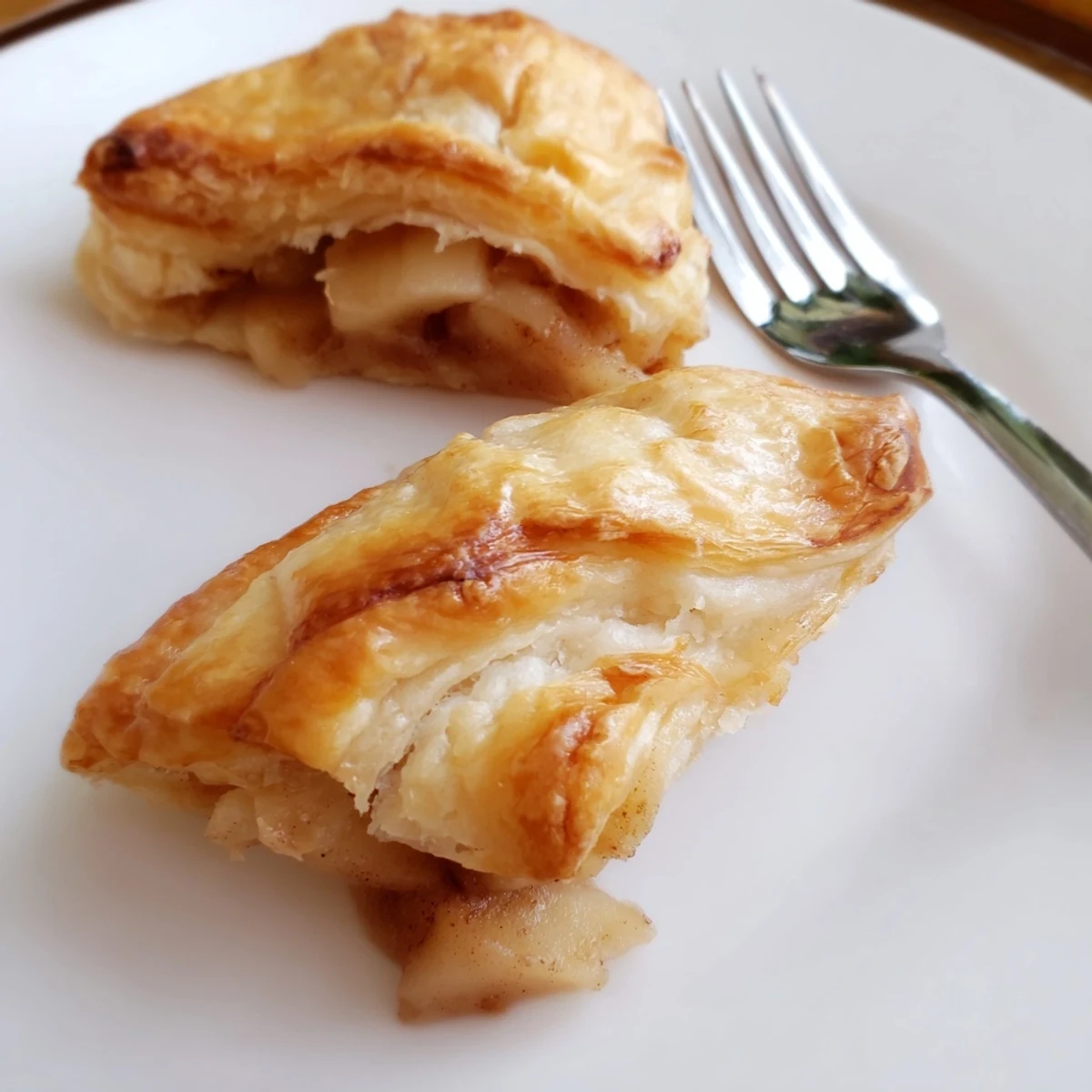 Golden flaky apple cheese danishes topped with warm spiced fruit and creamy glaze  