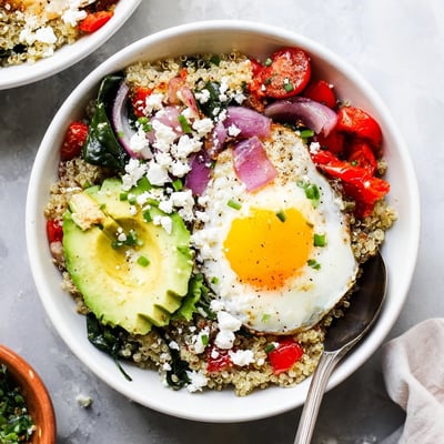 Hearty quinoa breakfast bowl featuring fluffy grains, wilted spinach, and perfectly cooked egg