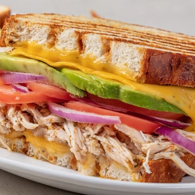 Sliced Chicken Avocado Melt Sandwich cross-section revealing layers of tender chicken, creamy avocado, and melted cheddar