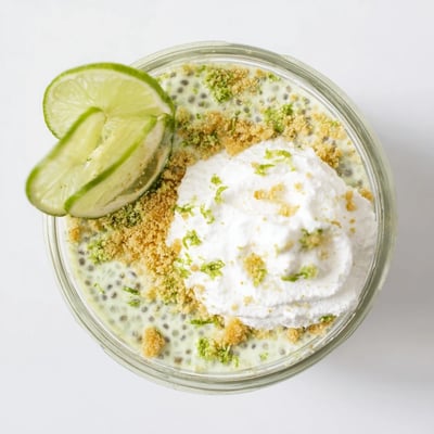 Green layered key lime chia pudding in glass jars with graham cracker crumbs